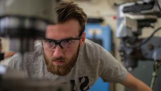 Student working at a press